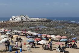 Image du Maroc Professionnelle de  Pour se désennuyer certains casablancais vont au bord de la mer, de la baie de la mosquée (Mriziga) jusqu’à l’îlot du rocher de sidi Abderrahmane environ sur 8 km de corniche. Une ambiance particulièrement locale très appréciée quelques visiteurs profitent du lieu sous les parasols pour manger des crêpes marocaines (Msamen) ou des galettes (Al Harcha) accompagné d'un thé à la menthe, avant de se donner aux joies de découverte avec leur petit de la vie marine sur les rocher qui entourent l’îlot. Les pèlerins accèdent au site pour se purifier, jeter un sort ou faire un sacrifice. Dimanche 7 Octobre 2012. (Photo / Abdeljalil Bounhar) 